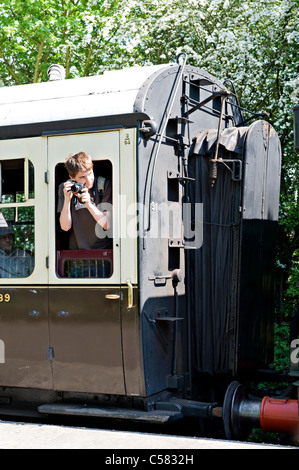 A railway enthusiast with camera on a train at the Didcot Steam Centre, UK