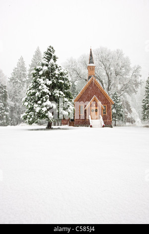 Yosemite Valley Chapel adorned in Christmas decorations during a snow storm - Yosemite National Park, California Stock Photo