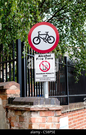 UK No Cycling sign, circular red and white, with cycle symbol. Above Alcohol Free Zone sign. Portrait Stock Photo