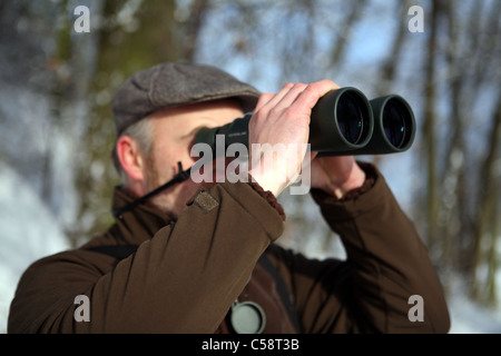 Man looking through binoculars Stock Photo