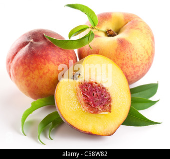 Ripe peach fruit with leaves and slises on white background. Stock Photo