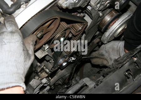 A Motor Technician in the Process of changing a Timing Belt Stock Photo