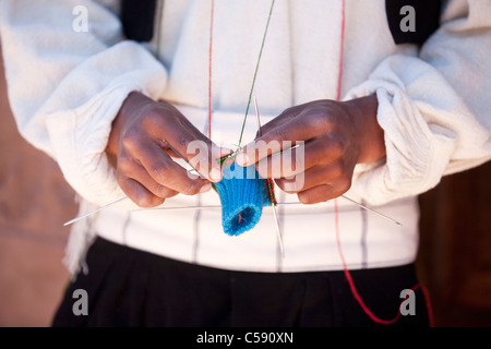 A male weaver of Taquile, a traditional island on Lake Titicaca knitting wearing a hat or chullo. They are woven on the island. Stock Photo