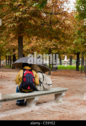 A couple shelter from the rain in the Jardin des Tuileries. Paris. France Stock Photo