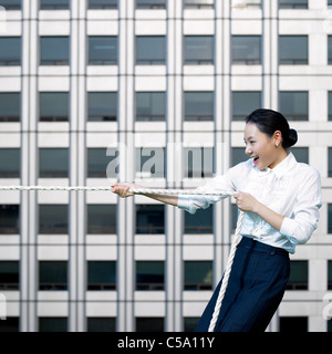 Side view of businesswoman pulling rope Stock Photo