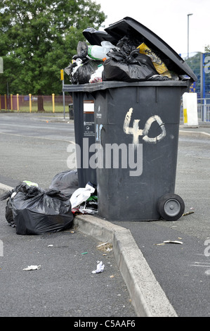 Wheelie bins overflowing with rubbish Stock Photo