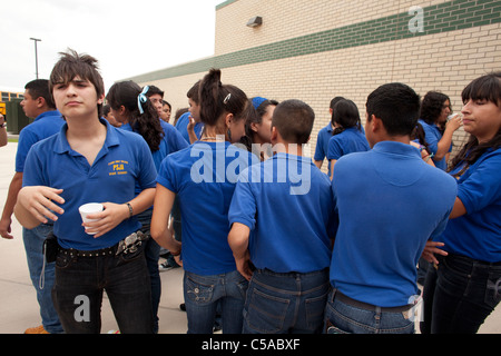 Group of male and female students wearing school uniform gather outside during change of class at high school in South Texas Stock Photo