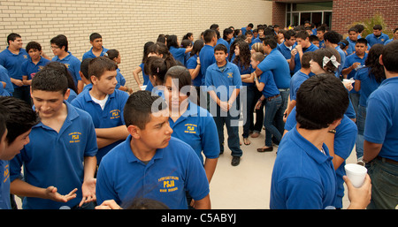 Group of male and female students wearing school uniform gather outside during change of class at high school in South Texas Stock Photo