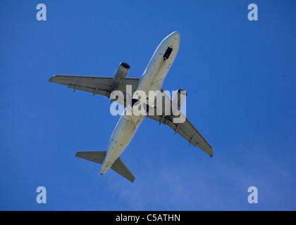 Bottom view commuter jet airplane against blue sky Stock Photo