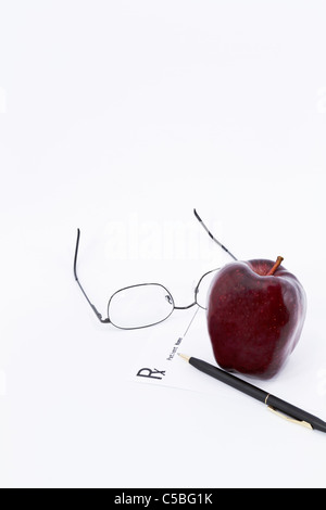 Prescription Rx, glasses, and apple depict back-to-school, medical check up time. Stock Photo