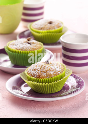 baked muffins with dry fruits and raisins on a brown wooden board ...