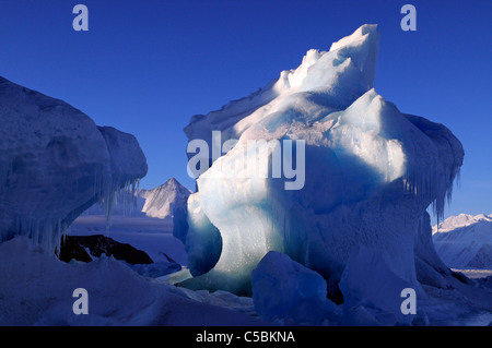Blue sky and Mount Herschel with iceberg set in sea ice in Ross Sea Antarctica Stock Photo