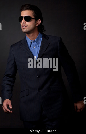 portrait of young fashion model wearing sunglasses on isolated black background Stock Photo