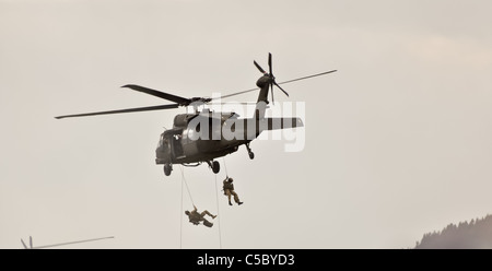 special forces team rappelling from a military helicopter Stock Photo