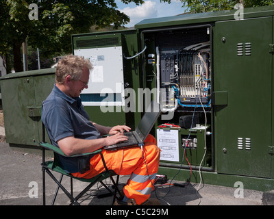 Engineer adding software to Fibre Optics Broadband Network Junction Box. Mossley,Lancashire,England, UK. Stock Photo