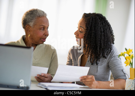 Daughter helping mother pay bills online Stock Photo