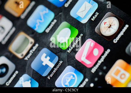 A close up of an illuminated Apple iPhone 4 screen showing the App Store and various apps Stock Photo