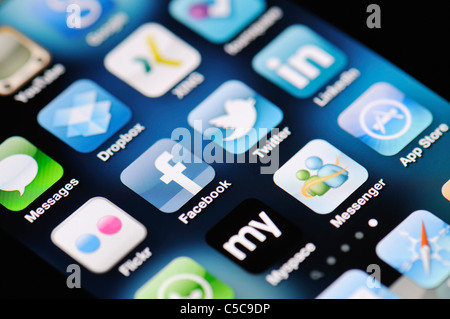 A close up of an Apple iPhone 4 screen showing the App Store and various social media apps Stock Photo