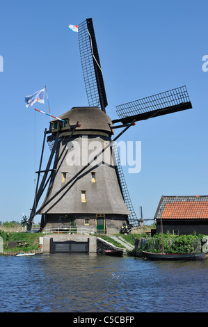 Thatched polder windmill along canal at Kinderdijk, a UNESCO World Heritage Site at South Holland, the Netherlands Stock Photo