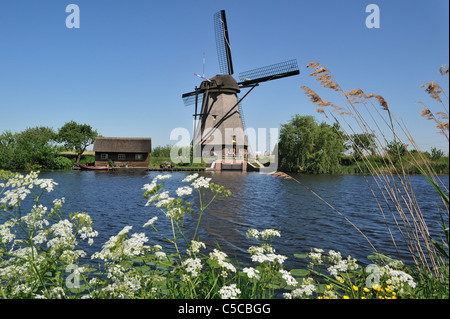 Thatched polder windmill along canal at Kinderdijk, a UNESCO World Heritage Site at South Holland, the Netherlands Stock Photo