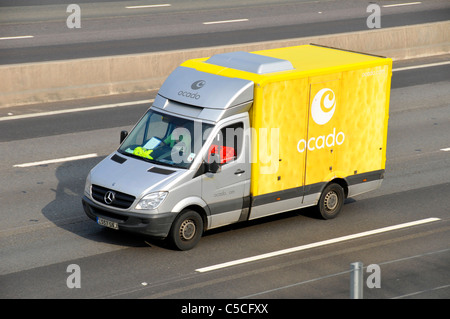 Side front & roof aerial view from above looking down yellow Ocado online grocery food shopping delivery van & logo driver on English UK motorway Stock Photo