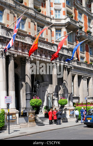 Flags above two doormen at the entrance to the luxury five star Mandarin Oriental Hyde Park Hotel in London Knightsbridge England UK Stock Photo