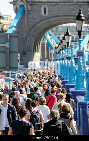 People walking along crowded pavement on approaches to Tower Bridge London Stock Photo