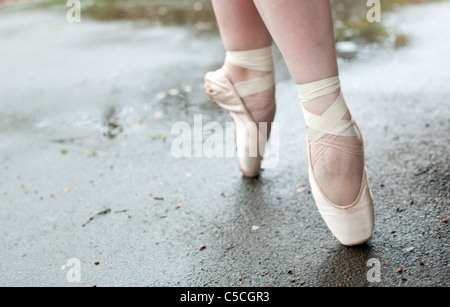 Ballet dancer's feet standing en pointe on wet ground , London, England, UK. Stock Photo