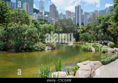 Picturesque Hong Kong Park with its artificial lake surrounded by the tall buildings of Central Stock Photo