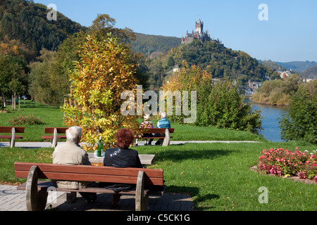 Senioren auf einer Parkbank mit Blick auf die Reichsburg,Cochem, Old couple on a bench with a view to the Cochem castle fall Stock Photo