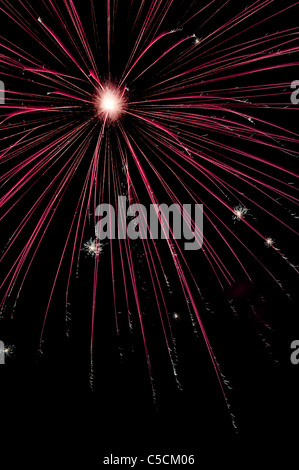 Red fireworks exploding in the night sky. A celebration of  color and explosions! Stock Photo
