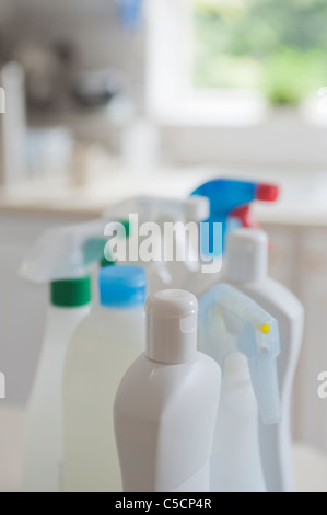 Collection of bottles containing different chemical cleaners in a domestic kitchen environment. Stock Photo