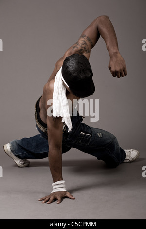 Modern man doing single handed steps on grey background Stock Photo
