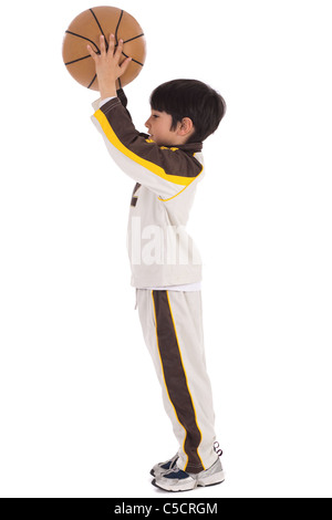 Little kid while throwing the basketball on white isolated background Stock Photo