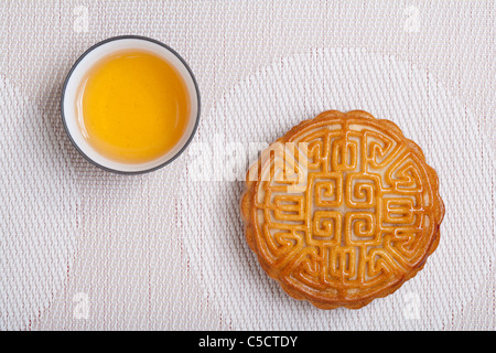 Moon Cake and Tea Cup on Geometric Place Mat Stock Photo