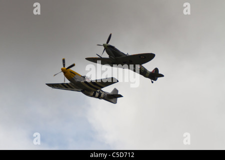 A P51 Mustang and a Spitfire fly together. Stock Photo