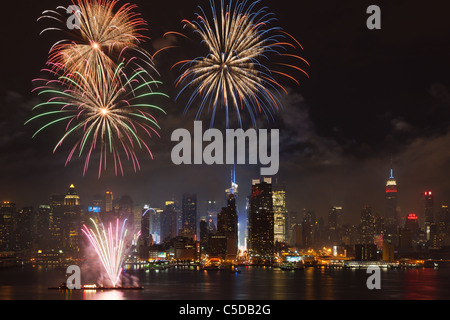 The Macy's 4th of July fireworks show lights the sky over the mid-town Manhattan skyline and Hudson River in New York City. Stock Photo