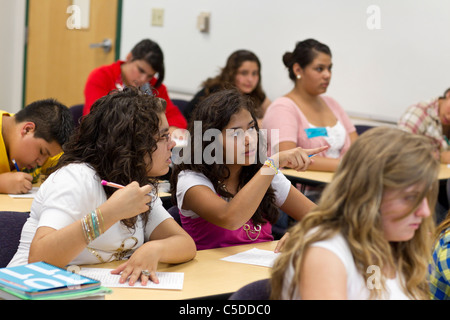students in South Texas high school classroom with 2 female Hispanic teens talk and discuss school work Stock Photo
