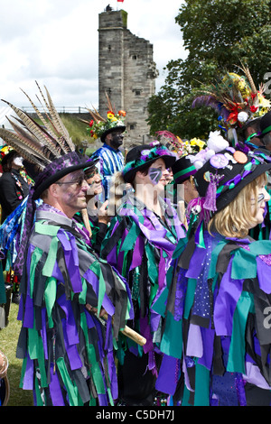 Exmoor Border Morris Dancers, black-faced, wearing long flowing torn old rags, clothing made from wide bolts of blue and white material, clothes & dancing celebration, outdoors event, street dancer, costumed dancers, Long flowing rags, cloggies, perform, performance, folk entertainers, multi colored, music festival, musicians, popular, performing traditional leisure activity at Tutbury Castle Weekend of Dance  Derbyshire, UK. Stock Photo