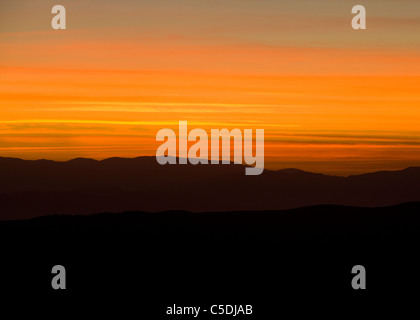 Sun sets behind North American Southwest desert mountains - California USA Stock Photo