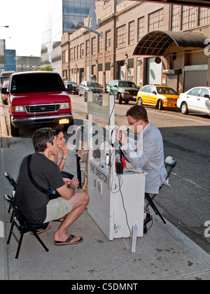 Passersby stop at the portable 'Homeless Museum of Art' on a sidewalk the lower west side of Manhattan, New York City. Stock Photo