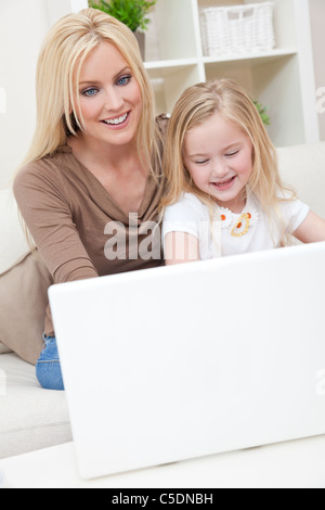 Woman and girl, mother and daughter, using a laptop computer together at home Stock Photo