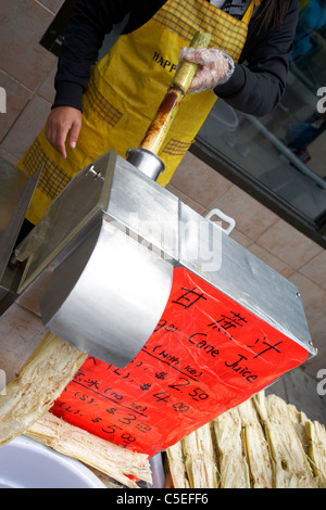 making fresh sugar cane juice for sale from a street vendor in chinatown toronto ontario canada Stock Photo