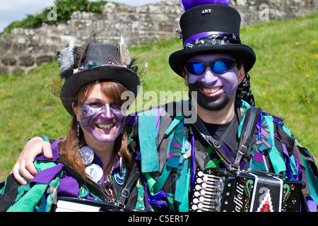 Exmoor Border Mixed Morris Dancers, black-faced, wearing long flowing torn old rags, clothing made from wide bolts of blue and white material, clothes Stock Photo