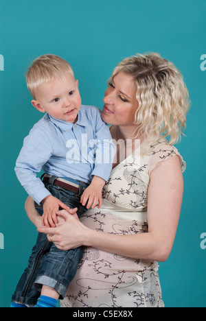Pregnant woman carrying her toddler son Stock Photo