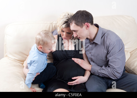 Pregnant woman with her son and husband talking at home Stock Photo