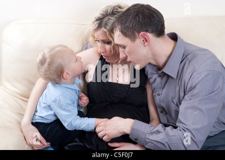 Pregnant woman and man talking to their toddler son Stock Photo