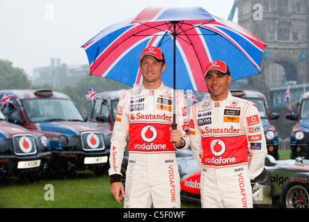 Former Formula 1 world champions Jenson Button and Lewis Hamilton attend a photocall in the pouring rain in London Stock Photo