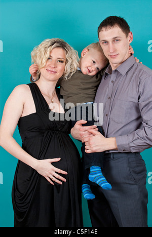 Portrait of happy pregnant woman with her partner and son smiling Stock Photo