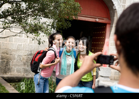 Young Man Taking a Photo of Three Friends Stock Photo